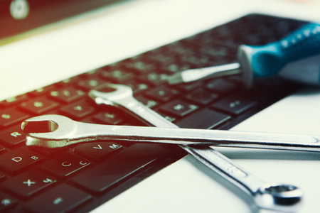 Electronic technical support concept. Wrenches on a computer keyboard.の写真素材