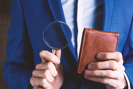 businessman holding a magnifying glass and wallet