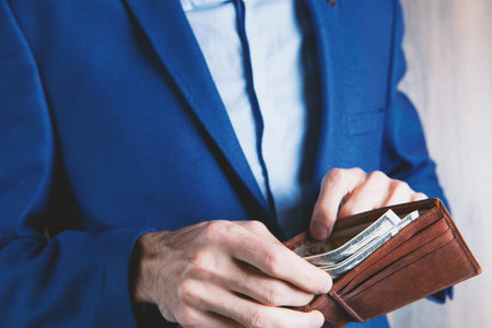 businessman holds wallet in his hands and counts money