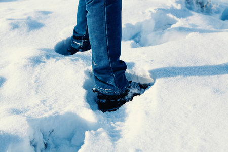 man walks in the snow in natureの写真素材