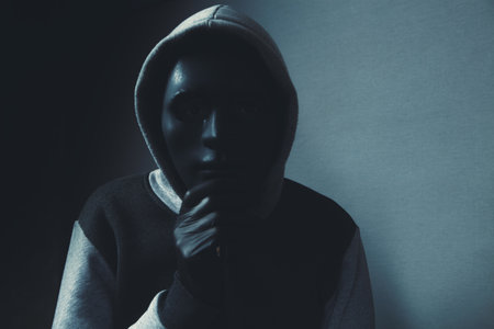 man with hood and black mask on his face