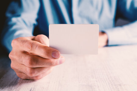 man holding a small paper in his handの写真素材