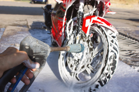 cleaning red sportbike in the car washの写真素材