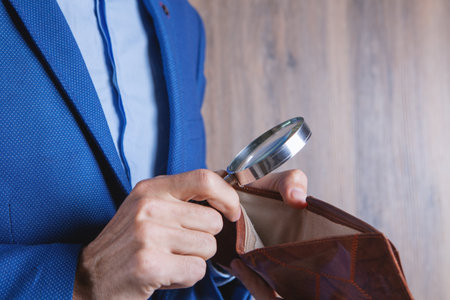 businessman holding a magnifying glass and wallet