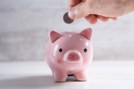 Young woman putting a coin inside piggy bank as savings for investment