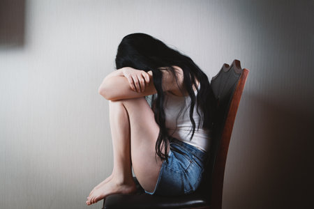 Beaten young woman sitting on a chair