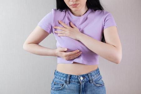 girl presses her hands on her chest chest painの写真素材