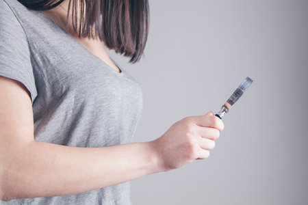 girl holding a magnifying glass in her hand and lookingの写真素材