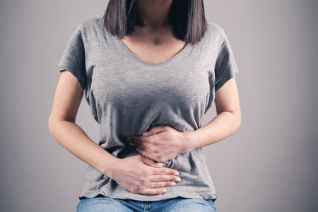 girl lying in bed suffering from stomach painの写真素材