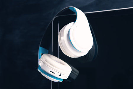 white headphones with computer listening to audio book or music