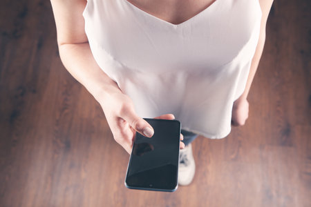 a young girl holding a phone in her handsの写真素材