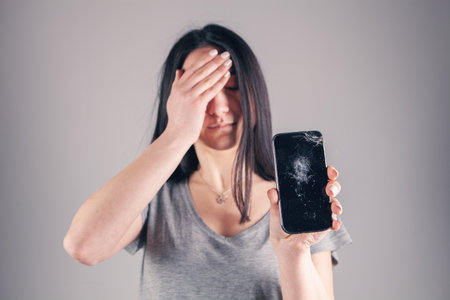 girl shows a broken phone.