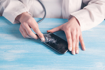 Smartphone being diagnosed by stethoscope - phone repair and check up conceptの写真素材