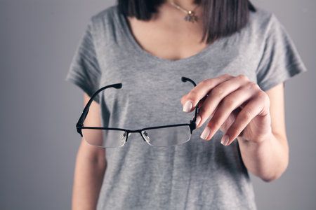 girl holding glasses in her handの写真素材