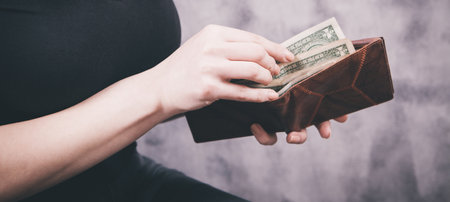 girl holds wallet in her hands and takes money