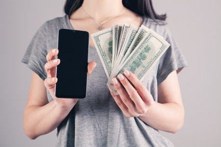 girl holding a phone and money