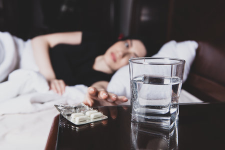 girl lying in bed suffering from stomach painの写真素材