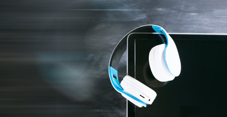 white headphones with computer listening to audio book or music