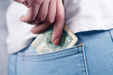young woman puts money in her back pocket. keep moneyの写真素材