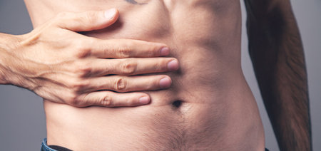 the man has a stomach ache on a gray background