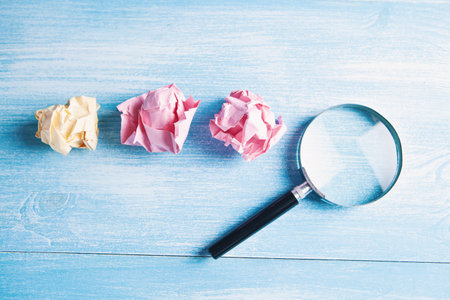 crumpled papers and a magnifying glassの写真素材