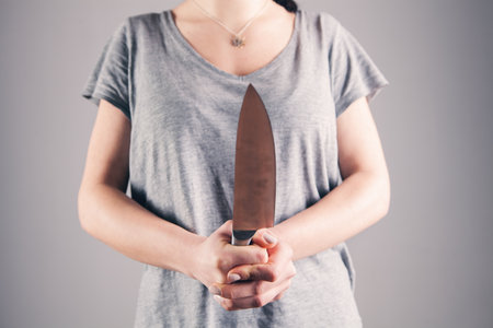 young woman holding a knife in front of her