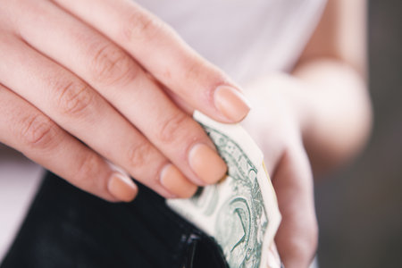 young woman puts money in walletの写真素材