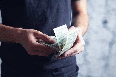 young guy counting dollar bills