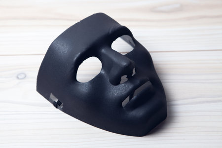 black mask of anonymous on the tableの写真素材