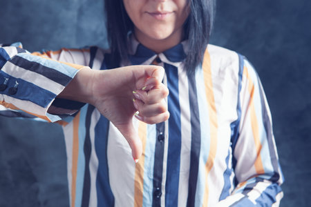 young woman showing thumb downの写真素材