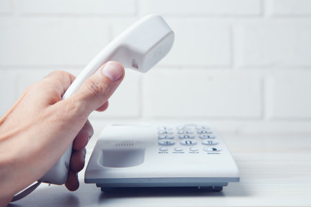 hand holding a home phone receiverの写真素材