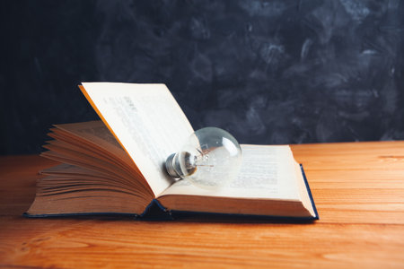 light bulb and book on the tableの写真素材