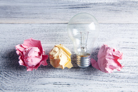 crumpled papers and a light bulb on the tableの写真素材