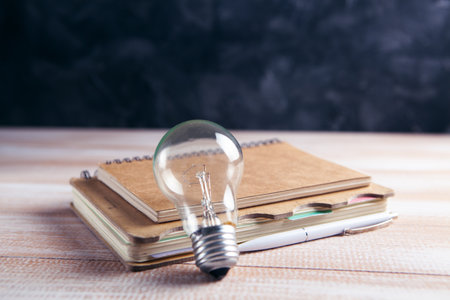 notepad and light bulb on the table. concept writing ideasの写真素材