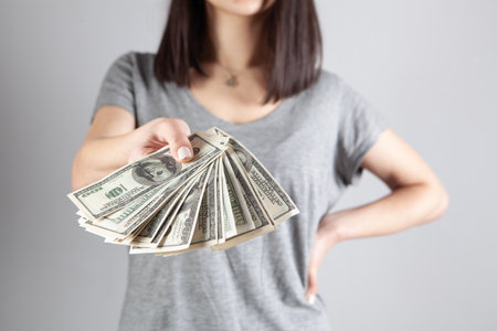 young girl gives dollar billsの写真素材