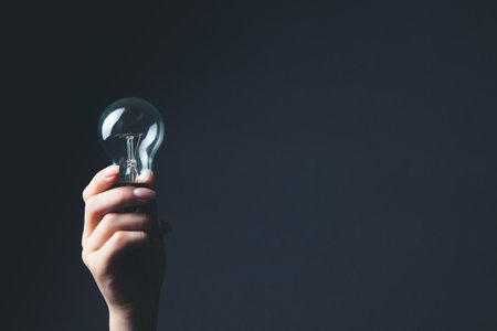 a woman's hand holding a light bulbの写真素材