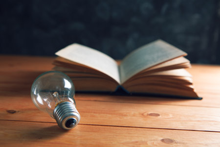 light bulb and book on the tableの写真素材