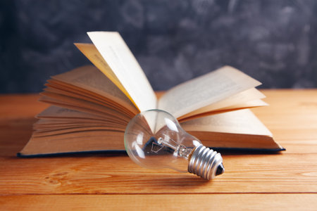 light bulb and book on the tableの写真素材