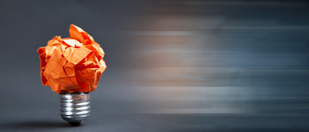 crumpled paper light bulb on black backgroundの写真素材