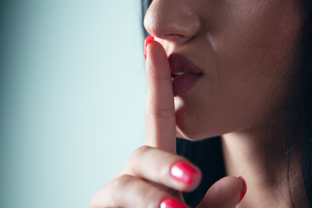 woman holding finger to lips showing silence gestureの写真素材