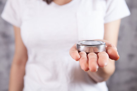 young girl holding a compass indoorsの写真素材