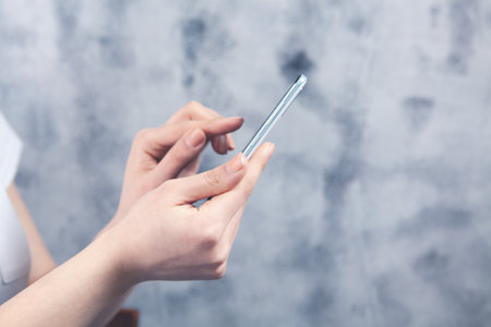 a young girl stands with a phone