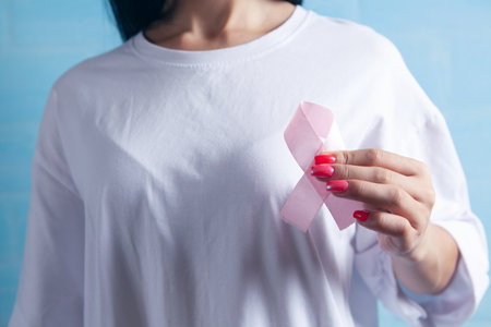 young girl holding a pink ribbonの写真素材