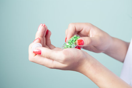young girl holding pills on gray backgroundの写真素材