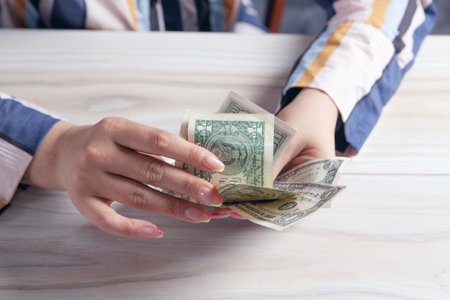 woman counting money at the tableの写真素材