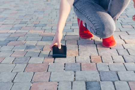 young woman picks up walletの写真素材