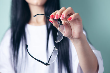 young woman holding optical glassesの写真素材