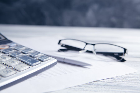 calculator, papers, glasses and pen on the table. desktop conceptの写真素材