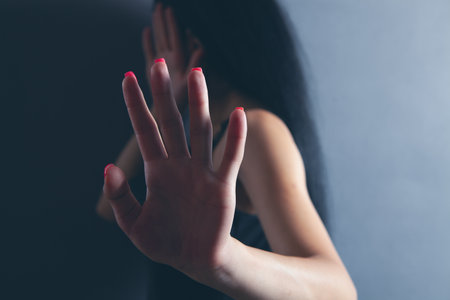 young woman covered her face in fearの写真素材
