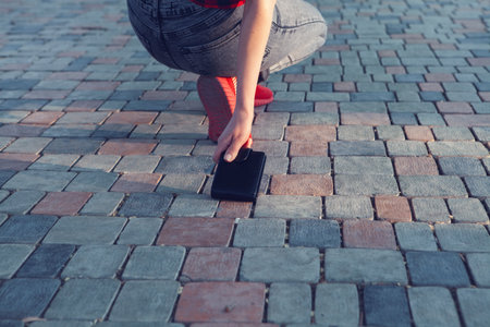 young woman picks up walletの写真素材